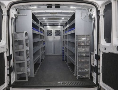 Aménagement intérieur d'un utilitaire avec étagères métalliques et bacs de rangement.