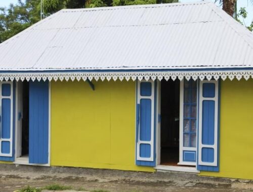 Case créole jaune aux volets bleus et toit métallique à La Réunion